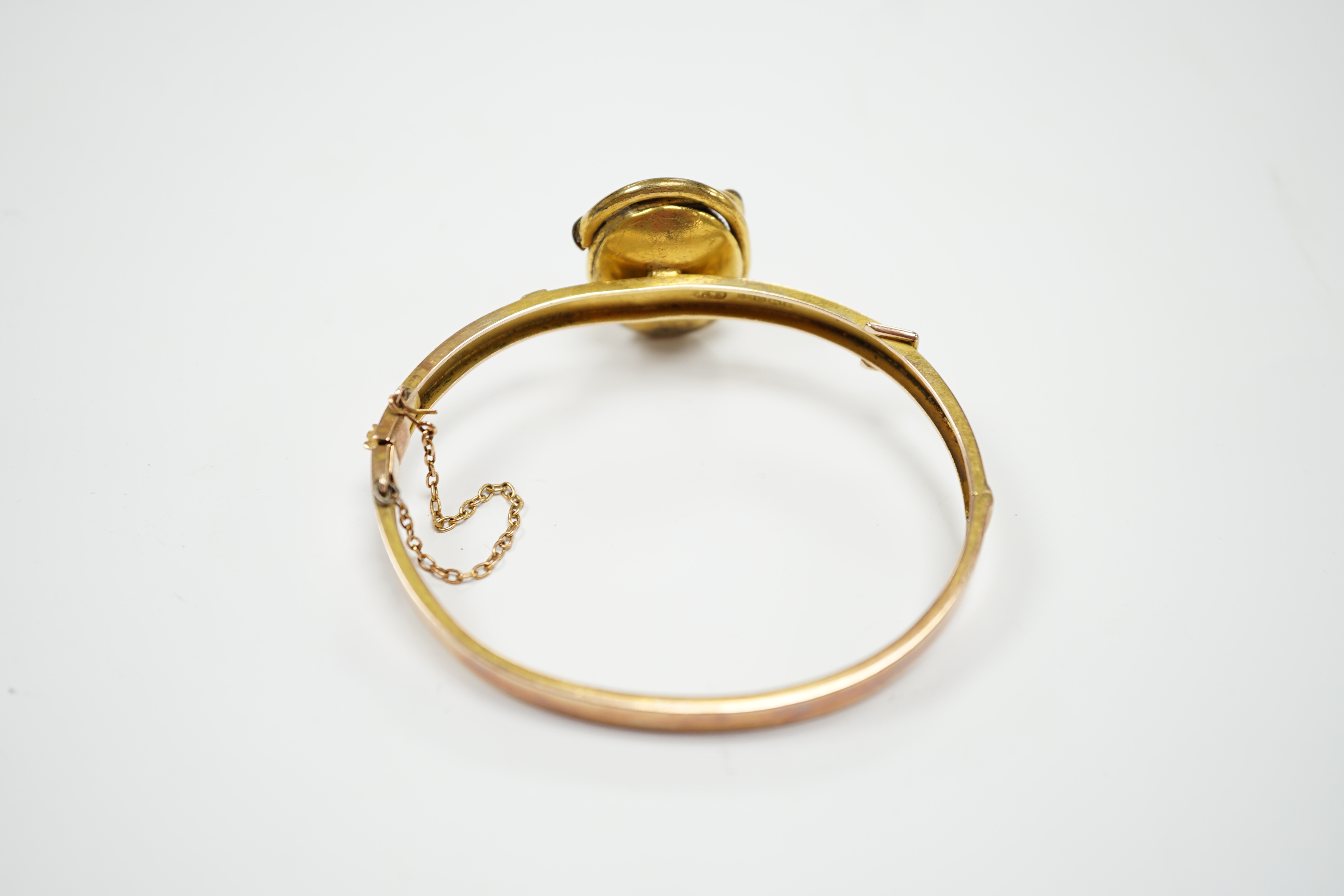 A late Victorian 9ct gold and single stone cabochon red paste set hinged bangle, gross weight 14.5 grams, (adapted?).